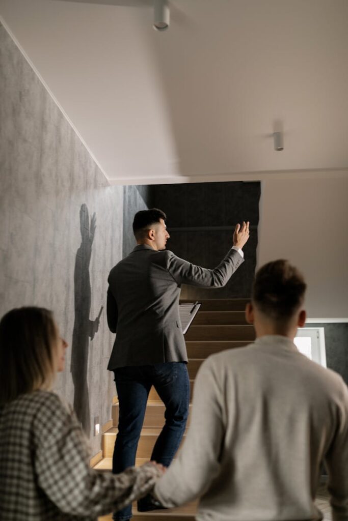Agente immobiliare accompagna una coppia durante una visita, mostrando gli interni di una casa moderna